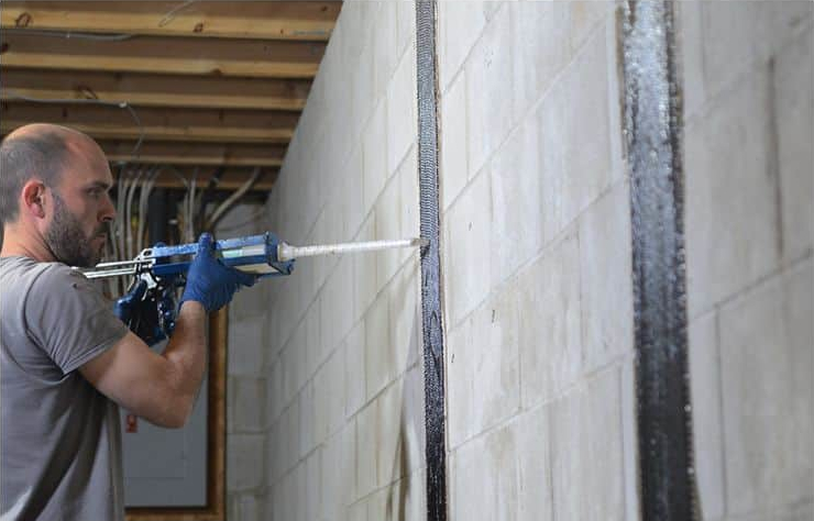 A male repairing the wall